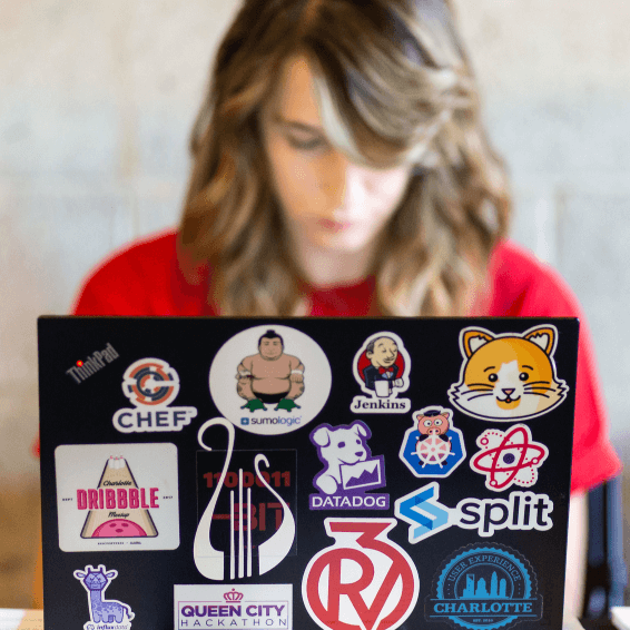 Attendee with laptop covered in tech stickers