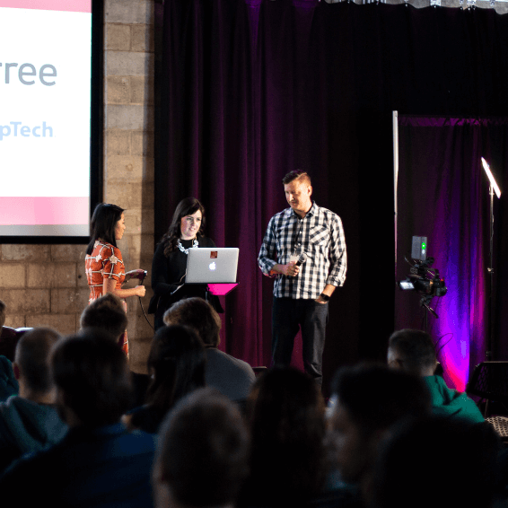 Three presenters on stage at FusionConf